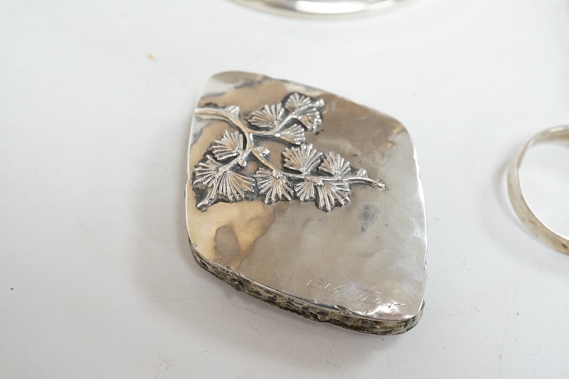 A George V silver and tortoiseshell pique mounted circular trinket box, Collett & Anderson, London, 1922, diameter 77mm, together with a pair of 18th century silver sugar nips and a sterling mounted pin cushion, decorate
